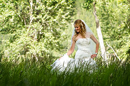 Bride walks through tall grass at Wallowa Lake in Joseph, Oregon