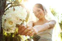 Bride holds her boquet out in front of her