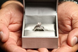 Hands holding the box with the diamond wedding ring
