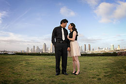 Engaged couple stands tall over San Diego skyline from Centennial Park