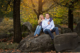 Engaged couple laughs in fall forest near Olympia