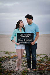 Engaged couple display their save the date sign