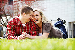 Engaged couple laughs on lawn in downtown Portland
