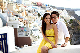 Couple poses with Oia in the background