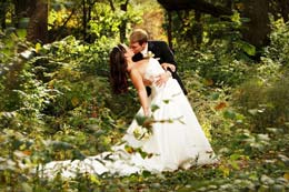 Groom kisses bride in the forest