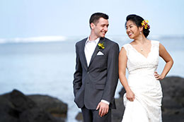 Bride and Groom pose on Hawaii's black rocks