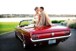 Bride and Groom pose with Red Mustang