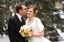 A wedding kiss on the cheek in the snow in Edmonton