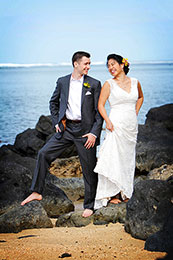 Bride and Groom pose barefoot on black rocks of Hawaii