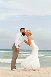 Bride pulls Groom in for a kiss by his suspenders in Playa del Carmen