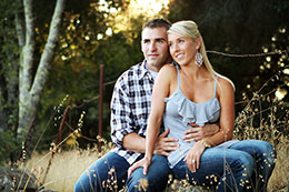 Lovely couple sits for a photo in a vineyard