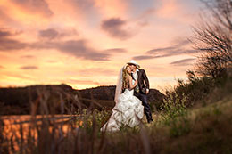 Wedding couple kisses on the banks of Rio Grande under a blazing sunset