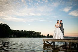 Keith and Erica stand on a dock at Lake Oconee during sunset