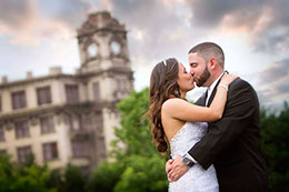 Kissing under a dramatic sky with the clock tower in the background