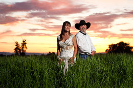Radient sunset behind bride and cowboy groom