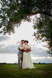 Bride and Groom embrase under a tree at 7N Ranch at sundown