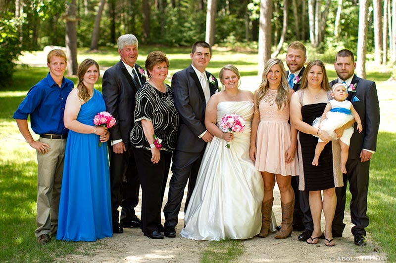 Bride and Groom pose with his family along gravel driveway in Cass Lake, Minnesota