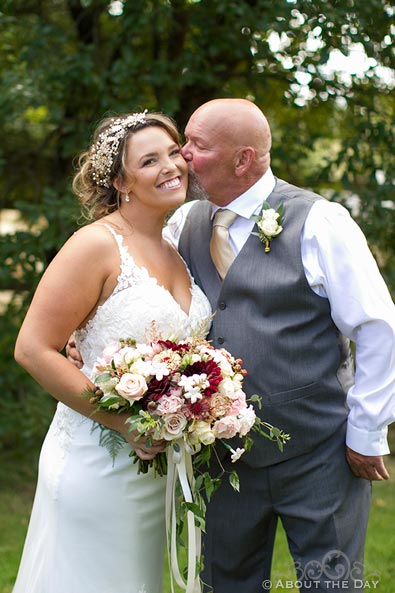 Father of the Bride kisses her on the cheek