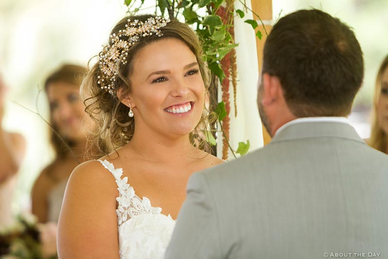 Beautiful bride looks on as Groom says his vows