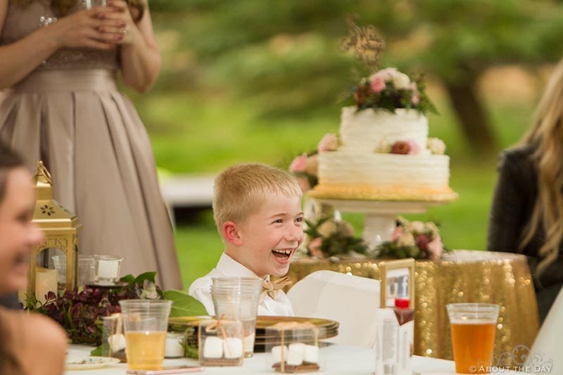 Ring bearer laughs at something during the speeches