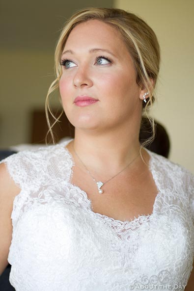 Stunning bride gazes out window with natural light