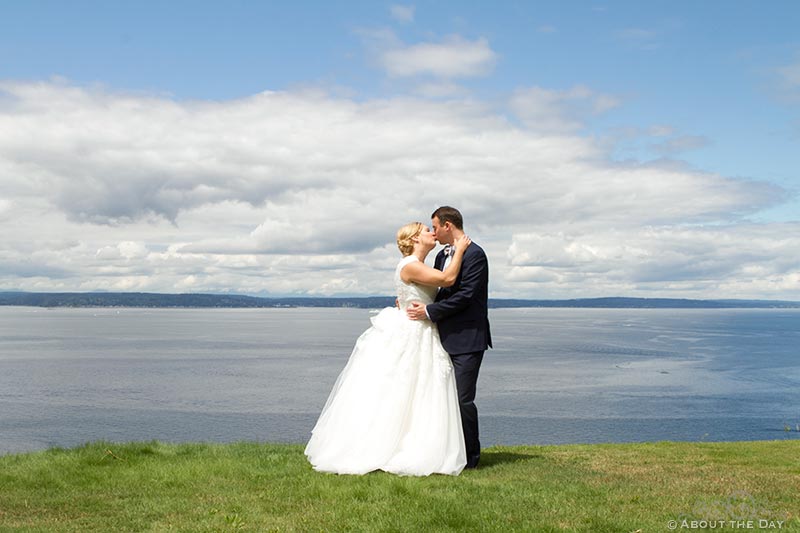 Bride and Groom kiss with a view of Puget Sound in the background
