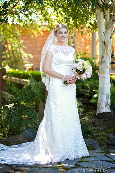 Beautiful Bride stands in the trees at Hidden Meadows
