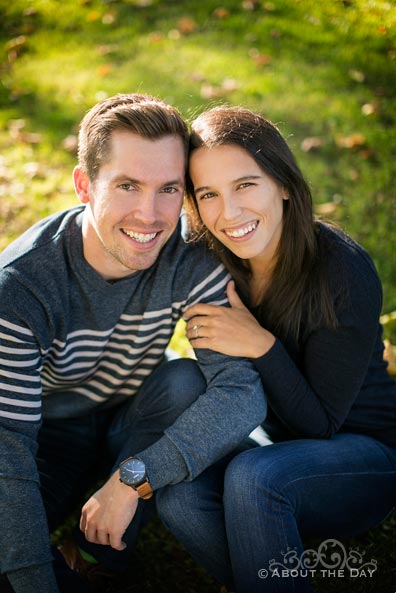 Engaged couple sit on the grass at Green Lake