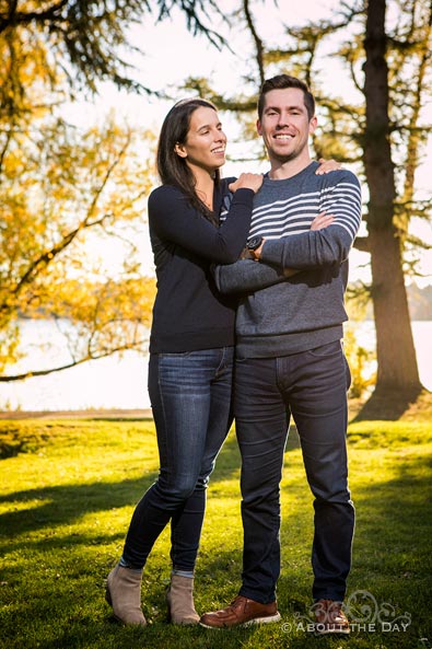 Engaged couple stand in the sun glow at Green Lake