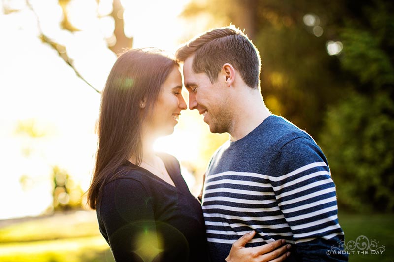 Engaged couple nussle in during sunset