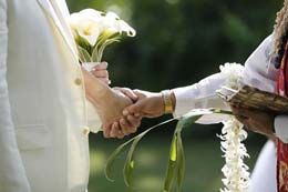 Clasping hands during Hawaiin wedding