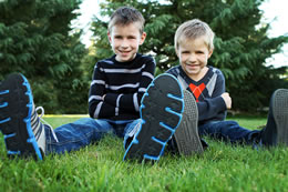 Blaine and Alex sit feet forward in the grass