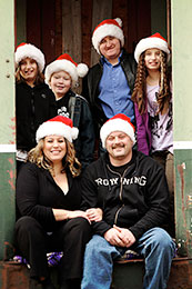 The Repar family sits in a old boxcar on for a Christmas card photo