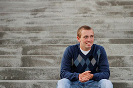 Chris sits on the concrete steps for senior photos