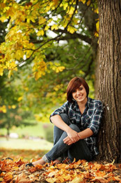 Rebekah poses for senior photos in the fall leaves
