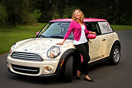 Cancer survivor poses next to her signed car