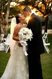 The sun shines through a passionate wedding kiss