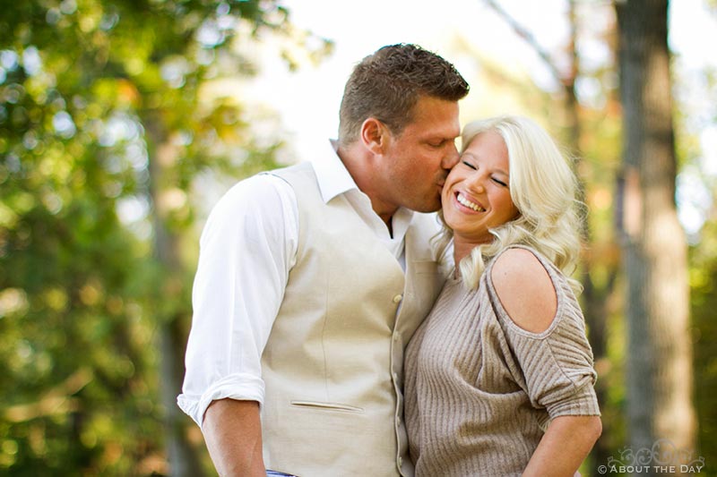 Engaged couple kiss with fall colors at Rock Cut State Park