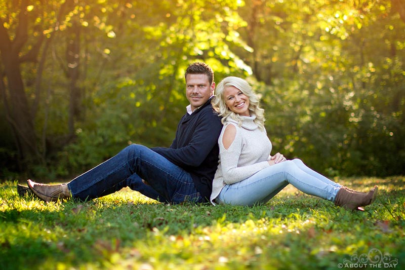 Engaged couple sit in the grass at Rock Cut State Park