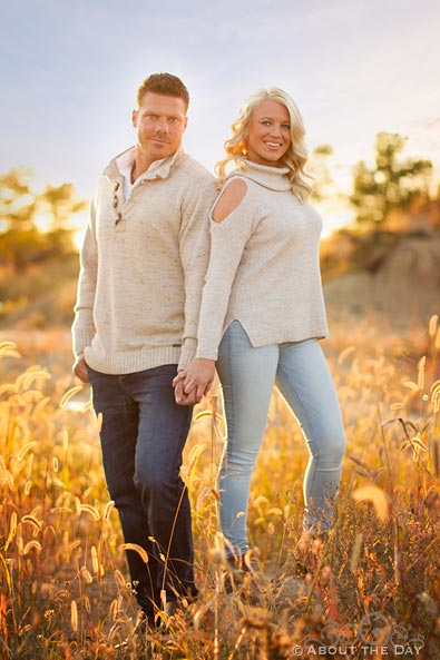 Engaged couple pose in the tall grass near Rockfort, IL