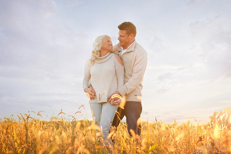 Engaged couple stand in tall grass near Rockfort, IL