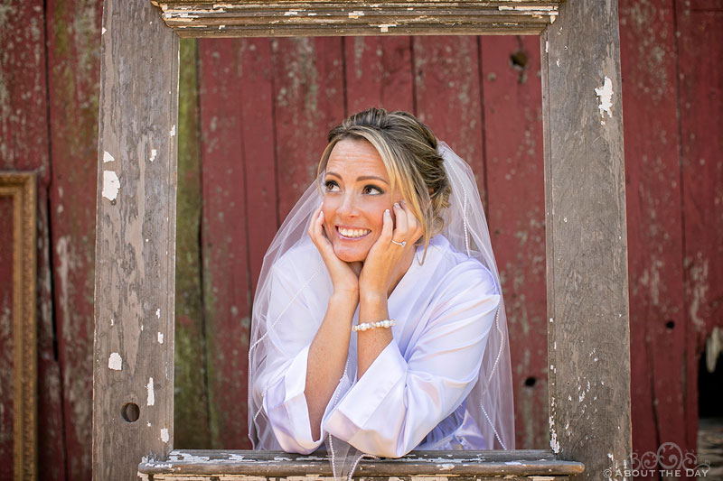 Bride peeks out of old wooden door at Youngs Dairy Farm in Auburndale, WI