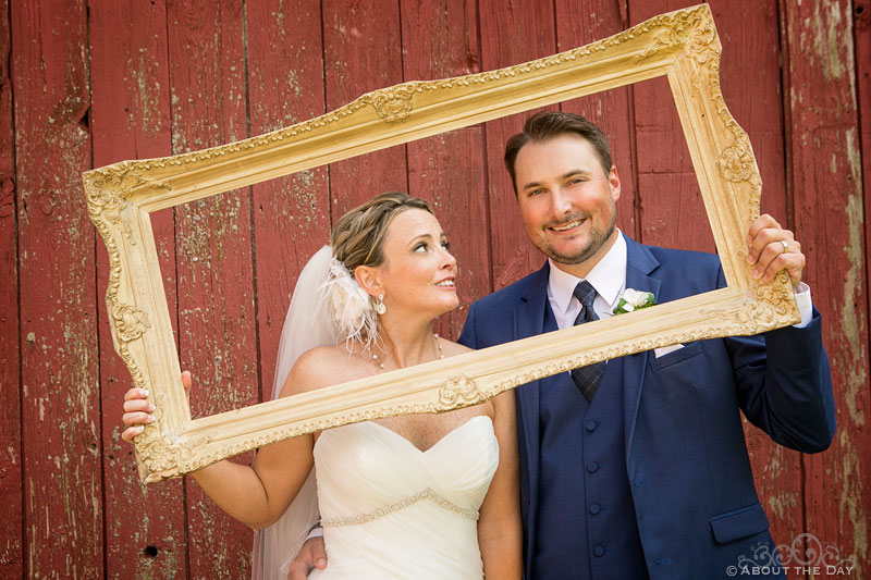 Bride and Groom hold their own frame for picture at Youngs Dairy Farm Barn in Auburndale, WI