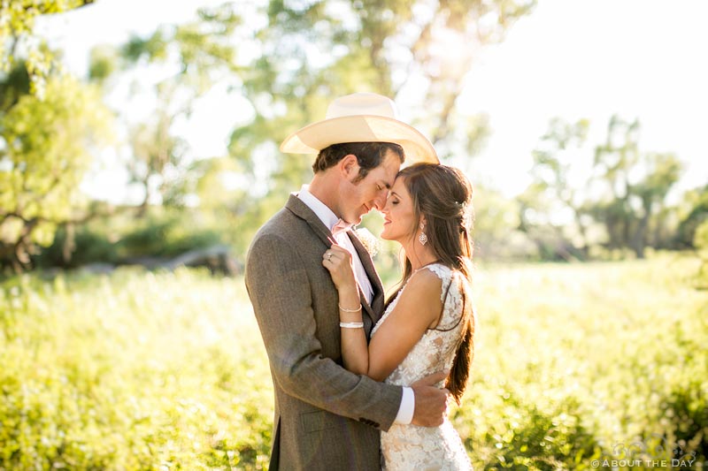 Bride and Groom pose together in sunlit trees