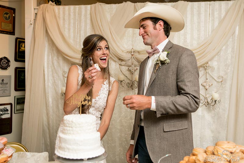 Bride and Groom play around with the wedding cake