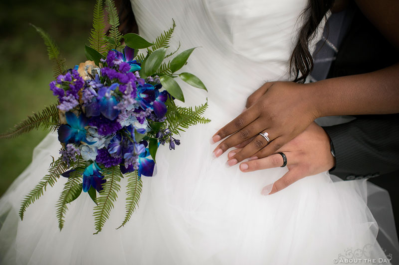Wedding rings, hands, and flowers