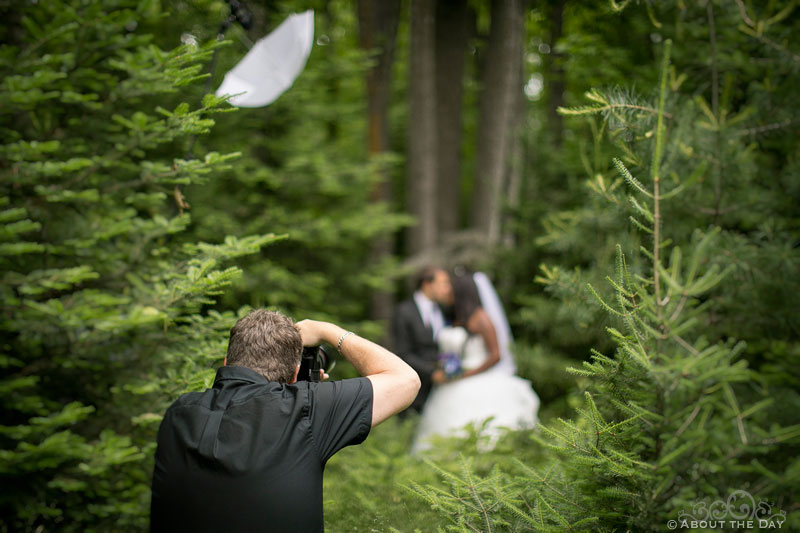Stephen is taking a photo of Bride and Groom in the woods