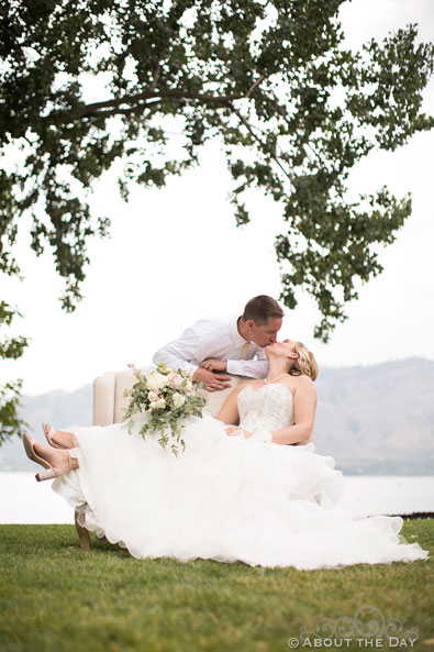 Chris and Paige kiss on a outside couch at Veranda Beach Resort in Oroville, Washington