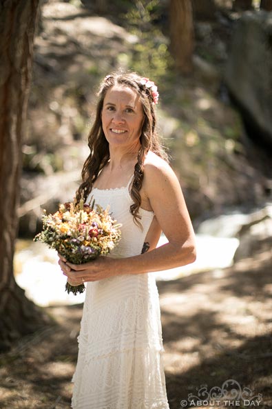 Bride poses along the creek in the woods