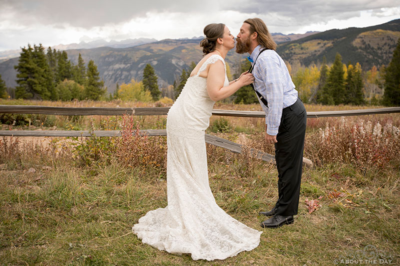 Bride pulls Groom closer by his suspenders for a kiss